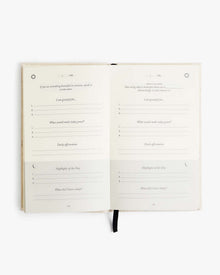 Open journal spread with printed prompts and blank writing lines.