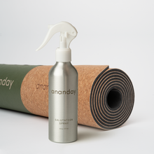 Ananday salutation spray bottle in front of a rolled cork yoga mat.