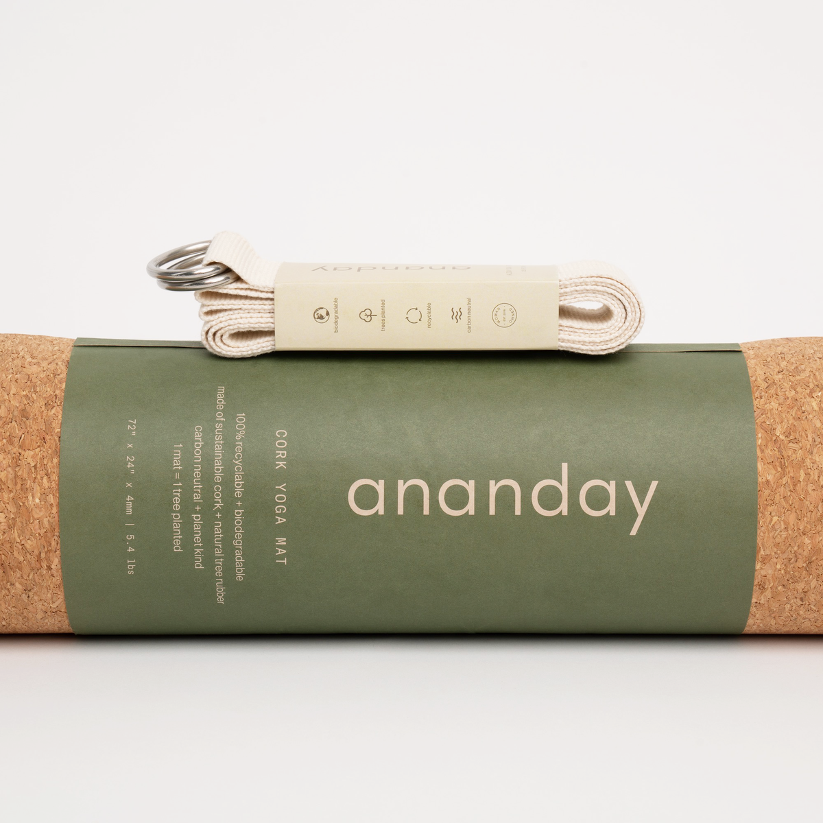 Folded Ananday yoga strap resting on a rolled cork yoga mat.