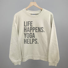 Cream sweatshirt on a hanger with visible printed text, Life Happens. Yoga Helps.