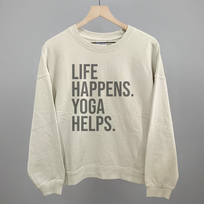 Cream sweatshirt on a hanger with visible printed text, Life Happens. Yoga Helps.