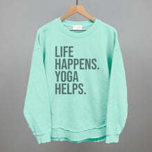 Mint textured long-sleeve top on a hanger with visible printed text, Life Happens. Yoga Helps.