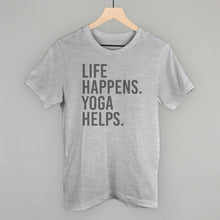 Light gray short-sleeve shirt on a hanger with visible printed text, Life Happens. Yoga Helps.