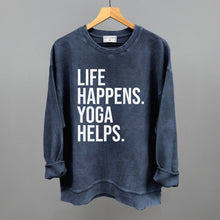 Dark blue textured long-sleeve top on a hanger with visible printed text, Life Happens. Yoga Helps.