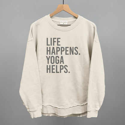 Cream long-sleeve top on a hanger with visible printed text, Life Happens. Yoga Helps.