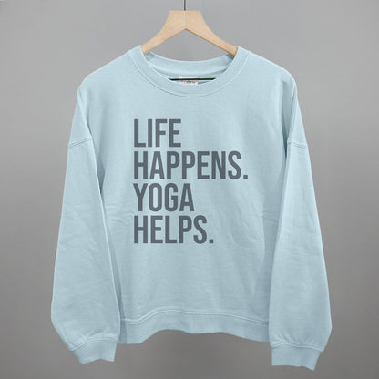 Light blue sweatshirt on a hanger with visible printed text, Life Happens. Yoga Helps.