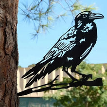 Black crow silhouette decoration attached to a tree trunk.