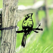 Black cardinal silhouette decoration attached to a tree trunk.