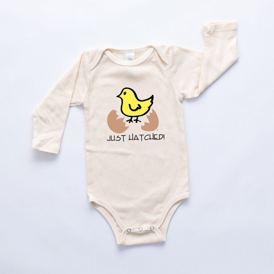 Natural cotton long-sleeve baby romper with a yellow chick and Just Hatched design