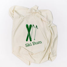 Natural cotton Ski Bum baby blanket with green skis folded on a white background