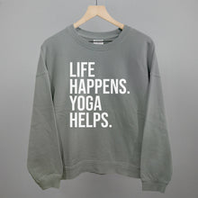 Gray sweatshirt on a hanger with visible printed text, Life Happens. Yoga Helps.