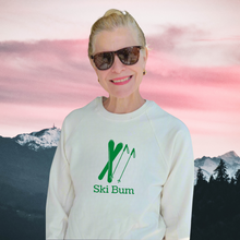 Woman wearing a natural cotton Ski Bum sweatshirt in front of a mountain background