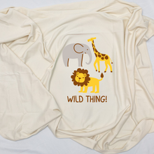 Close view of a natural cotton Wild Thing baby blanket with elephant, giraffe, and lion graphics