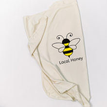 Natural cotton baby blanket with a yellow and black bee and Local Honey text