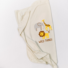 Natural cotton Wild Thing baby blanket with elephant, giraffe, and lion graphics folded on white