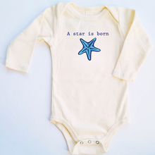 Natural cotton long-sleeve baby romper with a blue starfish and A Star Is Born text