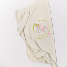 Natural cotton Nantucket Soul baby blanket with a pink bicycle design folded on a white background