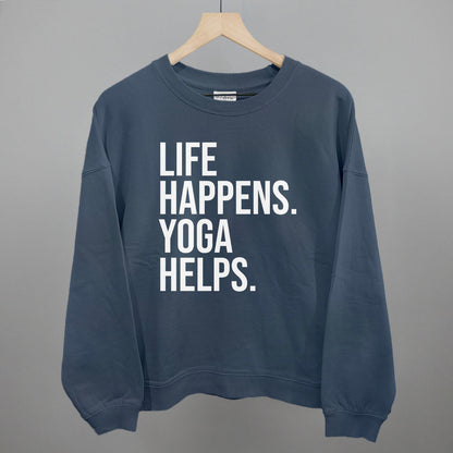 Blue sweatshirt on a hanger with visible printed text, Life Happens. Yoga Helps.