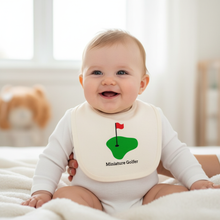 Baby wearing a white bib with green golf green, red flag, and “Miniature Golfer” text.