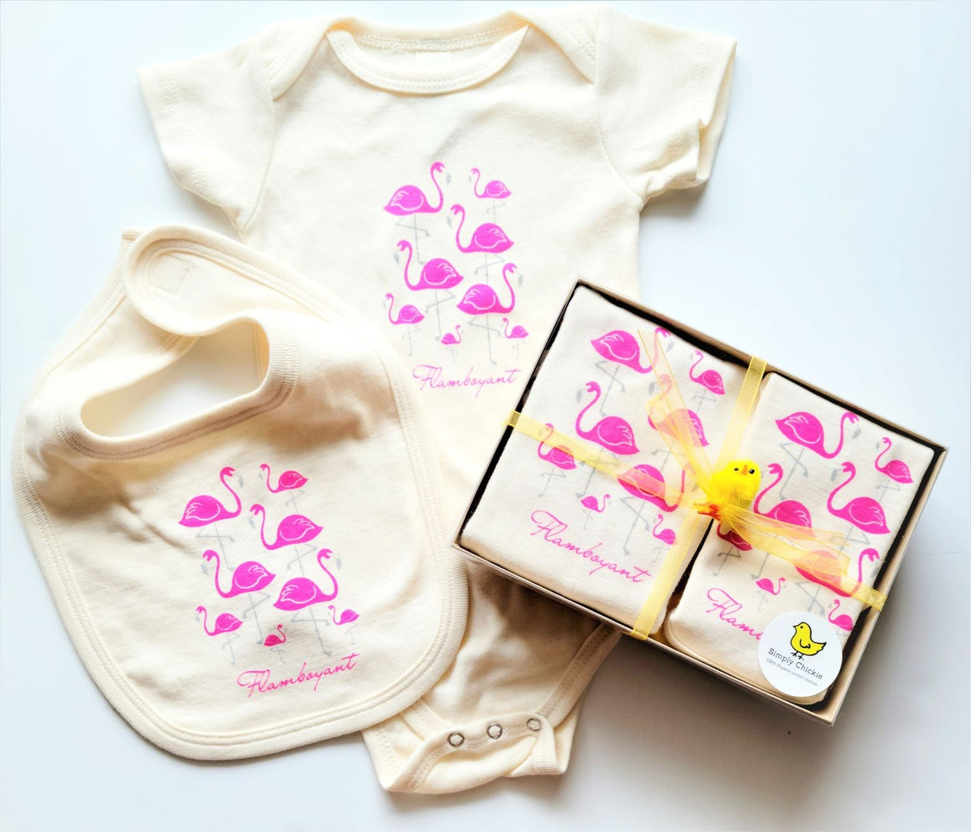 Flamingo natural cotton baby romper, bib, and boxed gift set arranged together