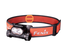 Black Fenix headlamp with an orange perforated headband on a transparent background.
