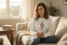 Woman wearing a natural cotton I Scream a Lot sweatshirt while seated with a mug