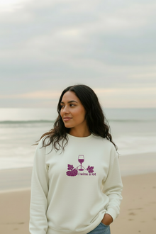 Woman wearing a natural cotton I Wine a Lot sweatshirt near the beach