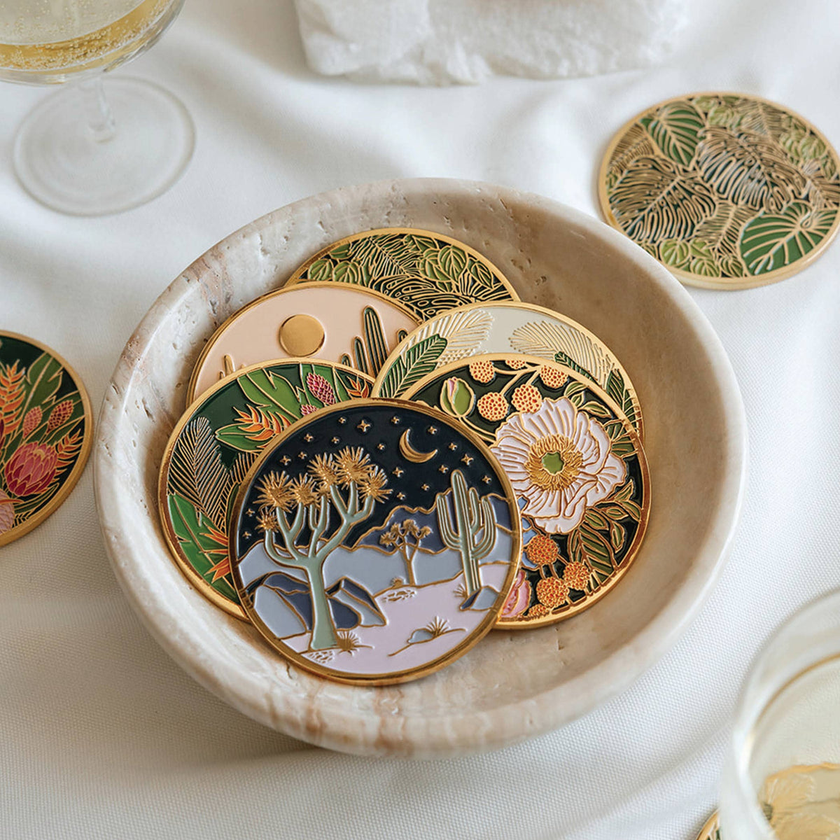 Moonlight Joshua Tree coaster displayed with colorful botanical enamel coasters in a shallow bowl