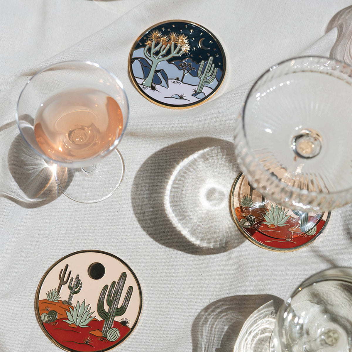 Moonlight Joshua Tree coaster styled on a white table among wine glasses and other desert coasters