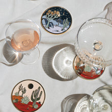 Moonlight Joshua Tree coaster styled on a white table among wine glasses and other desert coasters