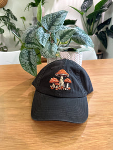 Black mushroom embroidered hat on table