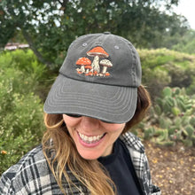 Person wearing black mushroom embroidered hat