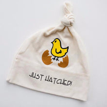 Natural cotton knotted baby hat with a yellow chick and Just Hatched design