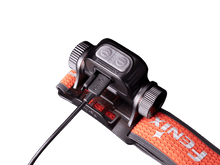 Close-up of a Fenix headlamp charging through a cable.