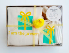 I Am the Present natural cotton baby romper and hat set arranged in a clear gift box
