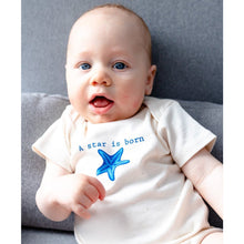 Baby wearing a natural cotton short-sleeve romper with a blue A Star Is Born starfish design