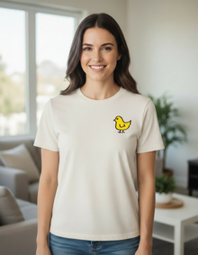 Woman wearing a natural cotton Local Chick T-shirt with a small yellow chick design