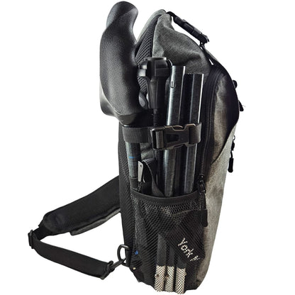 Side view of a gray backpack with folded black travel poles secured to the exterior.