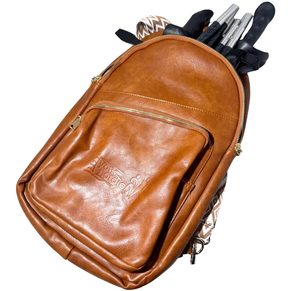 Brown York Nordic backpack holding folded black poles.